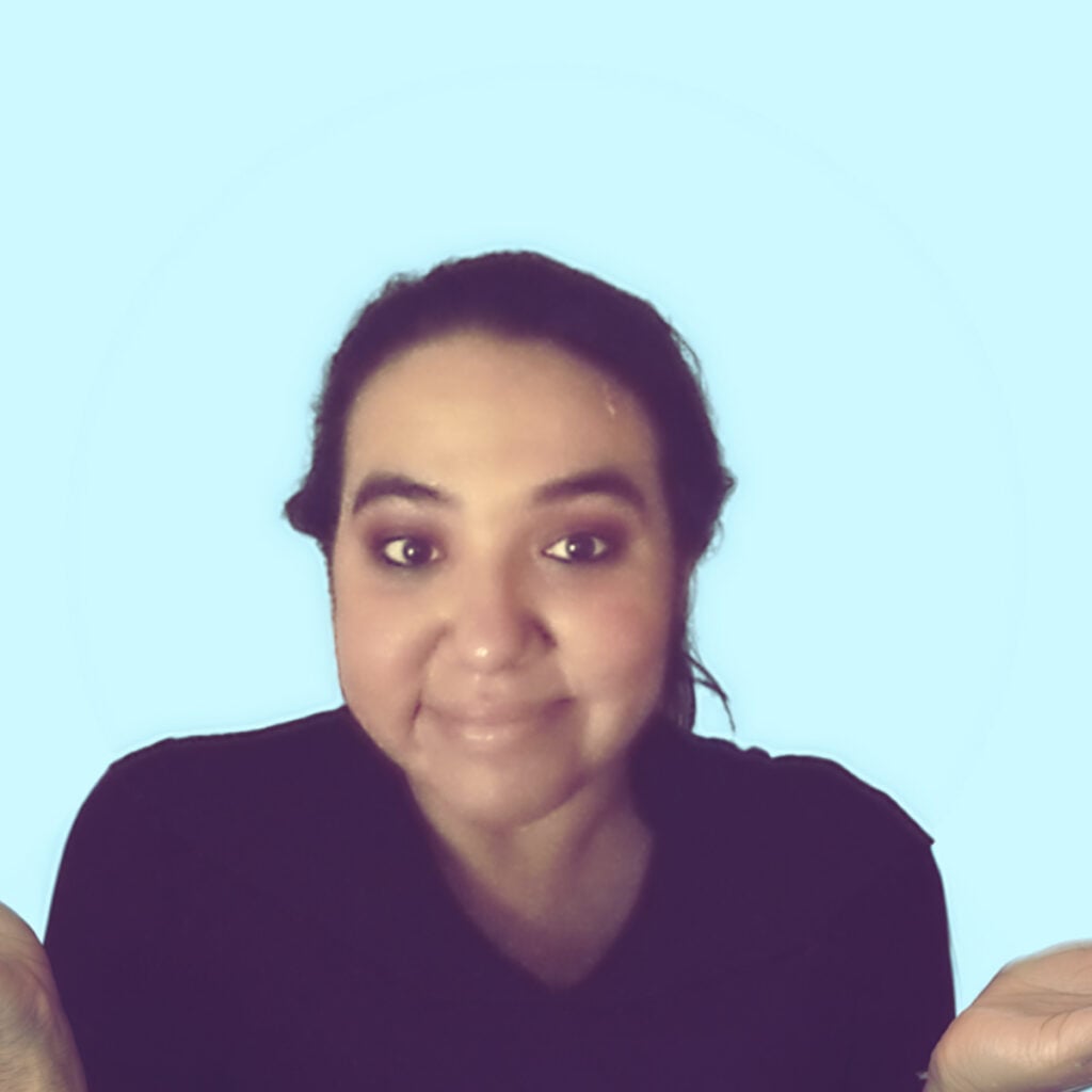 Woman with dark hair smiling against a light blue background.